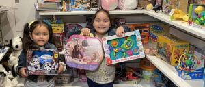 Two girls hold up toys