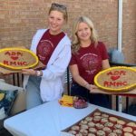 Volunteers hold up delicious treats at a fund raiser.