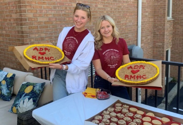 Volunteers hold up delicious treats at a fund raiser.